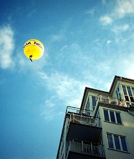 Gul luftballong över hus